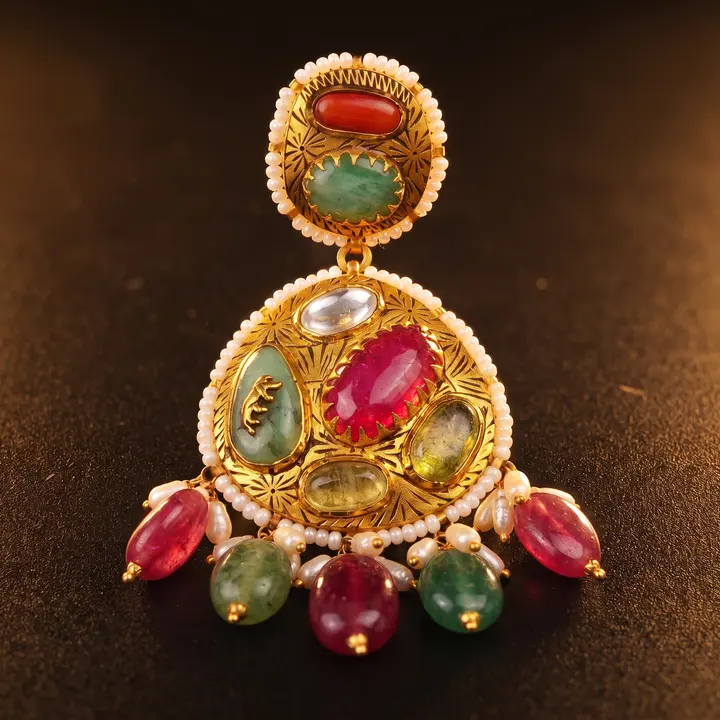 Macro of a kundan jadau earring with coral, green and ruby stones and pearl fringe on dark ground.