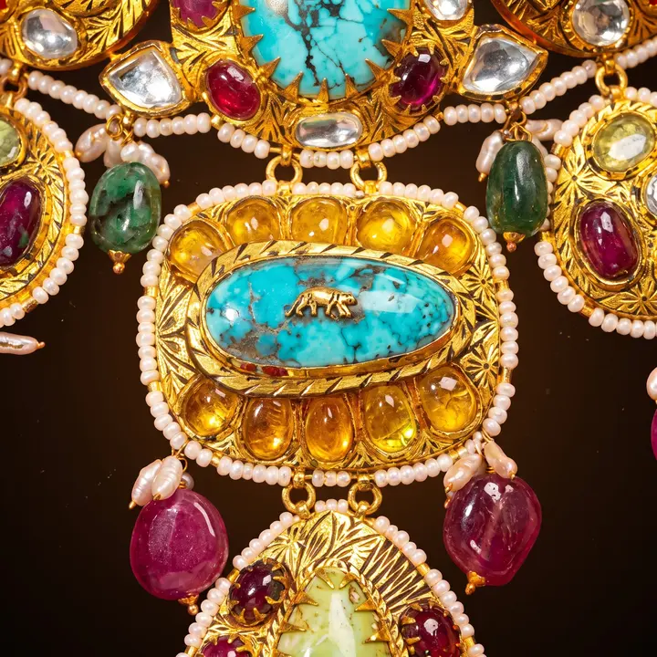 Macro of a polki plaque pendant with turquoise centre, rubies, emeralds and seed pearls.