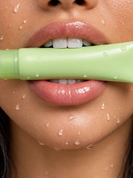 Beauty detail with a light-green tube and droplets